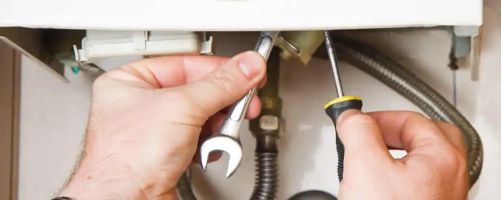 Boiler repair technician tightening pipe fittings and connections in Minneapolis, MN