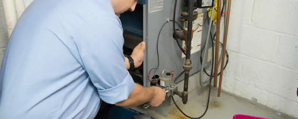 Furnace repair technician inspecting and servicing a home heating system in Minneapolis, MN