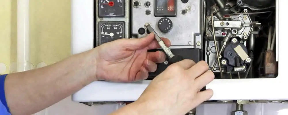 Heating repair technician adjusting boiler controls and components in Minneapolis, MN