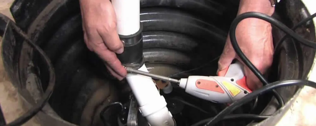 Sump pump installation technician connecting PVC discharge piping in Minneapolis, MN