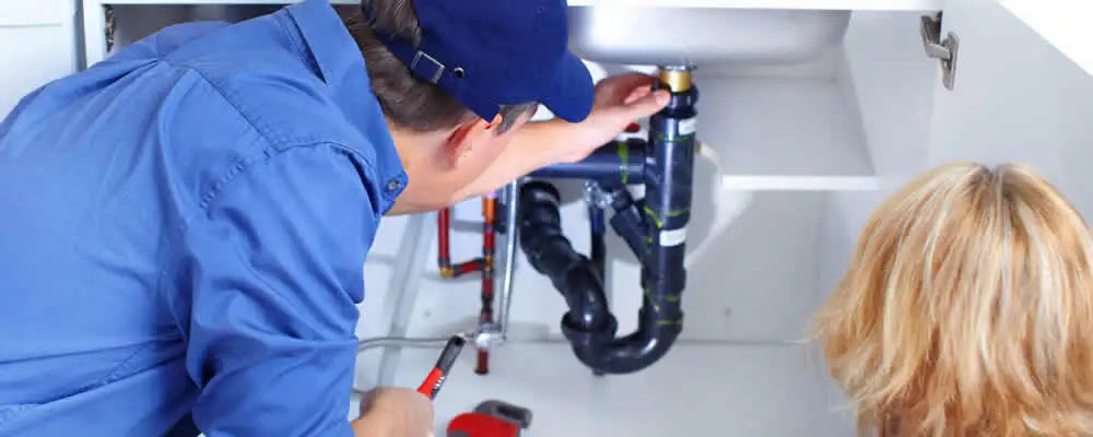Plumber repairing under-sink drain pipes and fittings in Minneapolis, MN